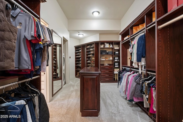 walk in closet with light carpet