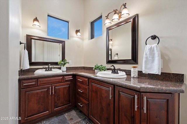 full bathroom with double vanity, a sink, and stone finish floor