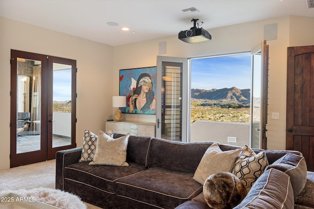 living room featuring a healthy amount of sunlight, a mountain view, french doors, and light colored carpet