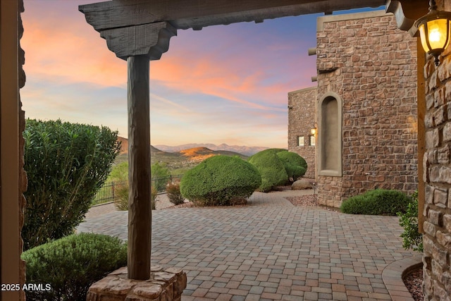 patio terrace at dusk with fence and a mountain view
