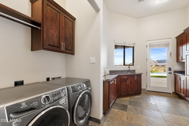 washroom with separate washer and dryer, a sink, visible vents, stone tile flooring, and cabinet space
