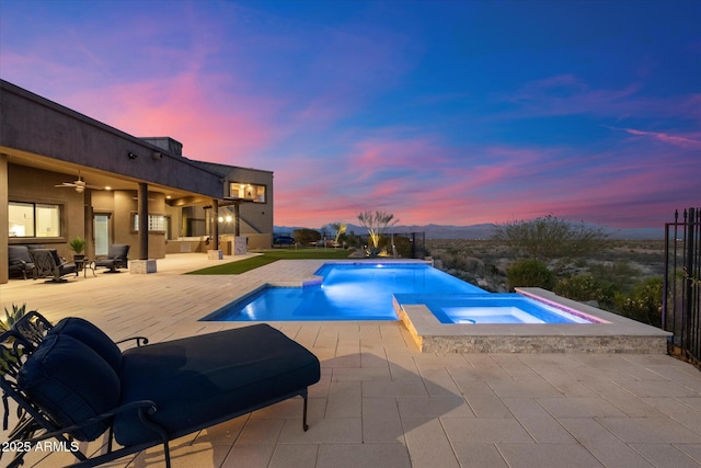 view of swimming pool with a patio, an infinity pool, and an in ground hot tub
