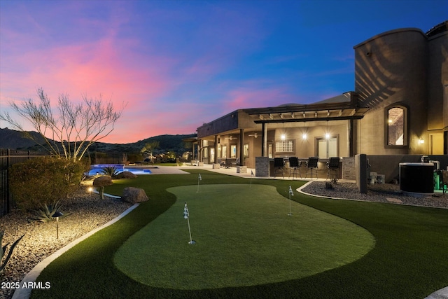 yard at dusk featuring a mountain view and a patio
