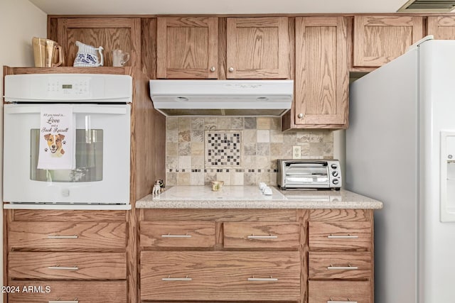 kitchen featuring backsplash and white appliances