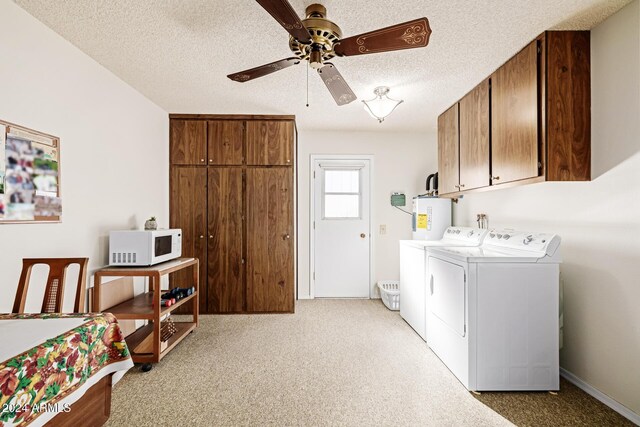 laundry area featuring cabinets, electric water heater, washer and dryer, ceiling fan, and a textured ceiling