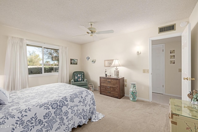 bedroom featuring ceiling fan, a textured ceiling, and light carpet