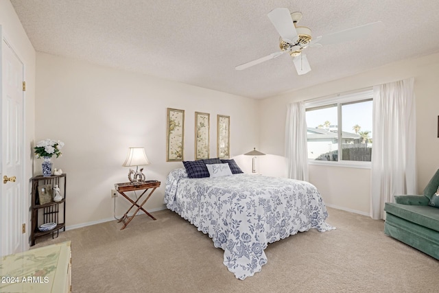 bedroom featuring ceiling fan, carpet floors, and a textured ceiling