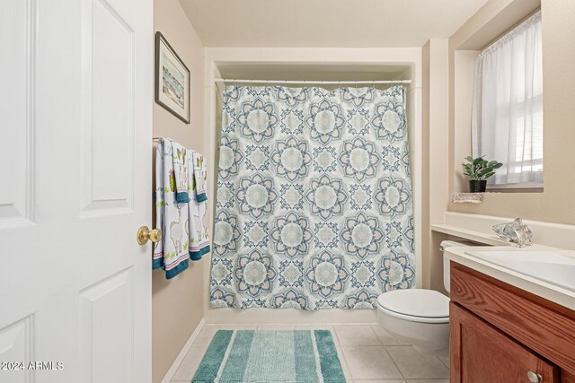 full bathroom featuring tile patterned flooring, vanity, toilet, and shower / bath combo with shower curtain