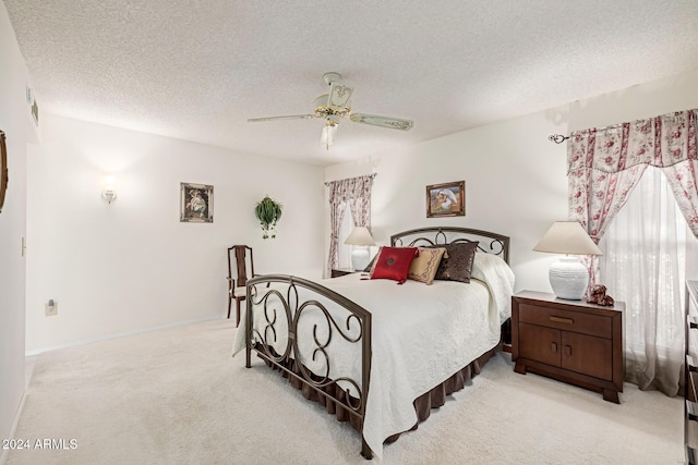 carpeted bedroom featuring ceiling fan and a textured ceiling