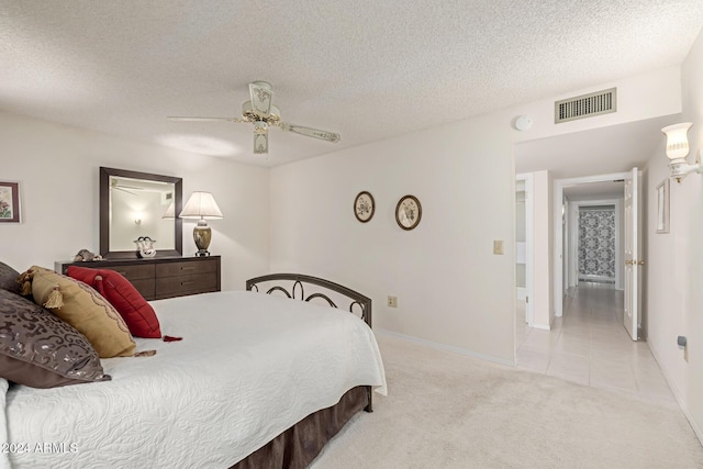 bedroom with light carpet, a textured ceiling, and ceiling fan