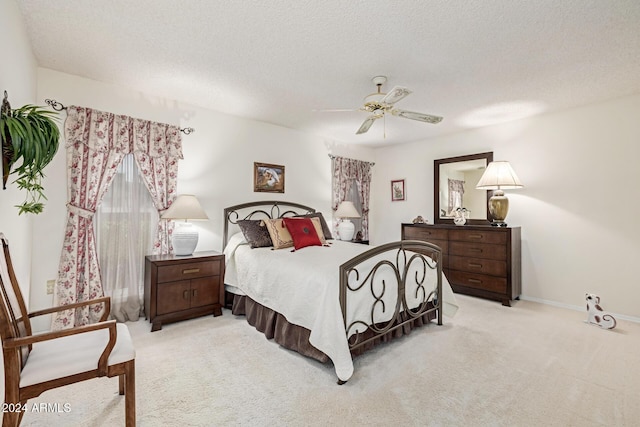 carpeted bedroom with ceiling fan and a textured ceiling