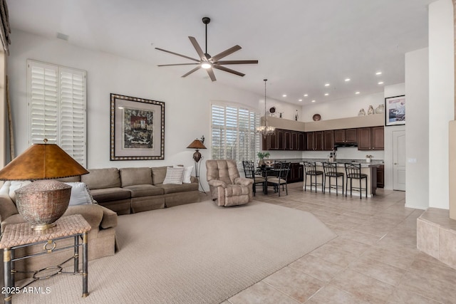 living area featuring ceiling fan with notable chandelier, light tile patterned floors, and recessed lighting