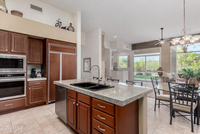 kitchen with a sink, visible vents, light tile patterned flooring, and stainless steel appliances