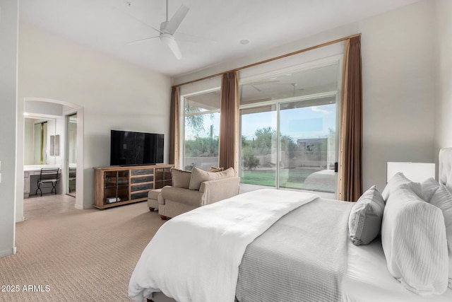 bedroom featuring access to outside, carpet flooring, ensuite bathroom, ceiling fan, and arched walkways