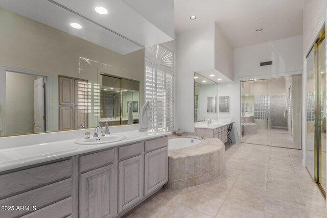 bathroom featuring a sink, a bath, two vanities, and tile patterned flooring