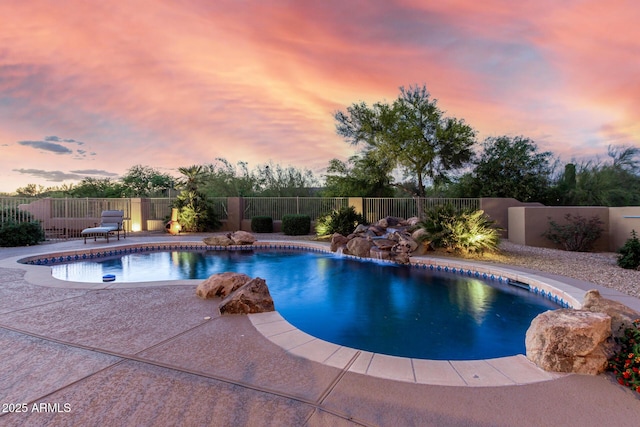 pool at dusk featuring a fenced backyard, a fenced in pool, and a patio