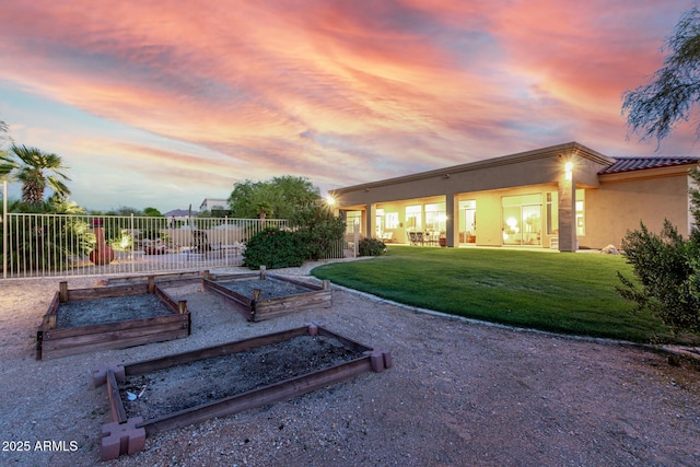 yard at dusk with a garden and fence