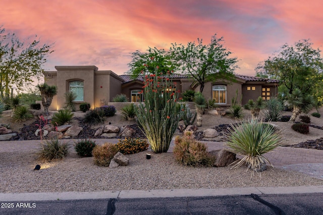 pueblo-style house with stucco siding and a tiled roof