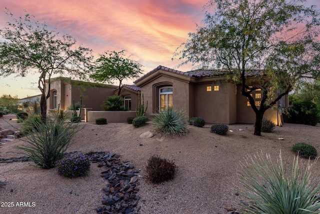 view of front of home featuring stucco siding and a tile roof