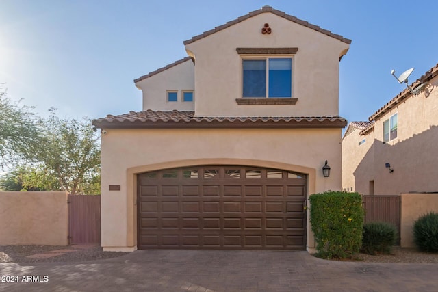 mediterranean / spanish home with a garage