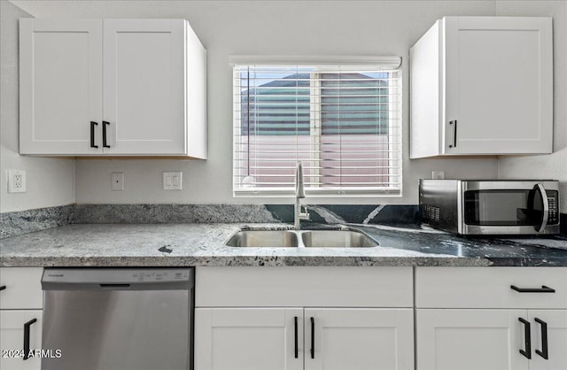 kitchen with white cabinetry, stainless steel appliances, sink, and a wealth of natural light