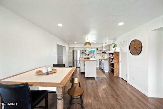 dining area featuring recessed lighting, dark wood finished floors, and baseboards