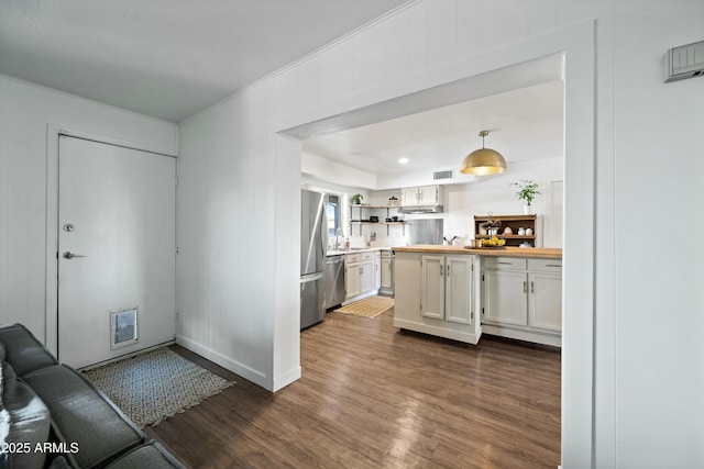 kitchen featuring a sink, white cabinetry, appliances with stainless steel finishes, open shelves, and dark wood finished floors