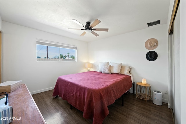 bedroom featuring visible vents, ceiling fan, baseboards, and wood finished floors