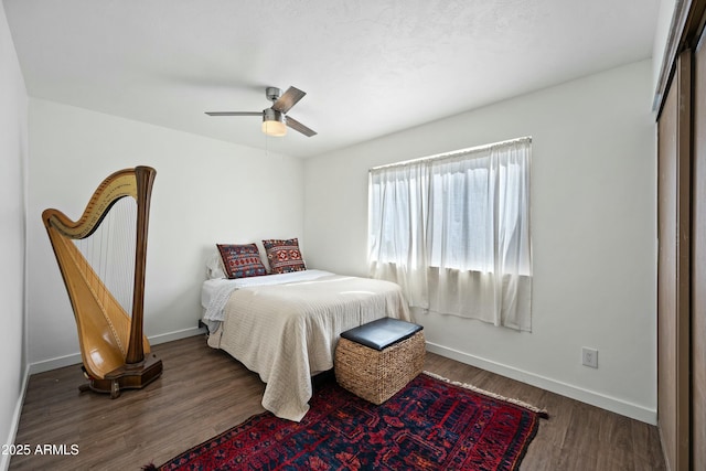 bedroom featuring ceiling fan, baseboards, and wood finished floors