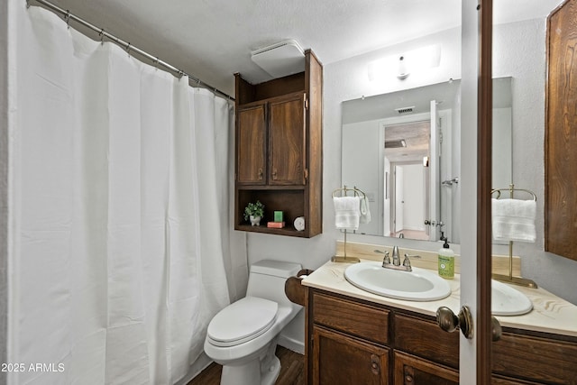 bathroom featuring toilet, visible vents, and vanity