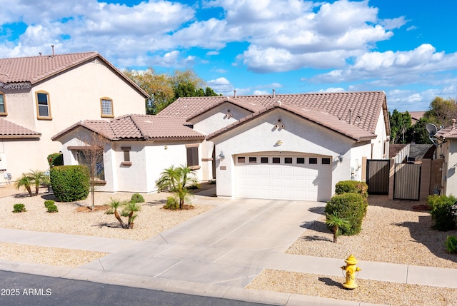 mediterranean / spanish-style house with a garage, a tile roof, driveway, a gate, and stucco siding