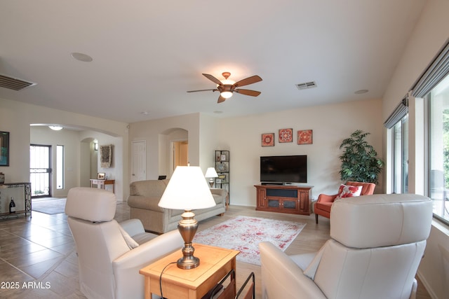 living room featuring arched walkways, visible vents, ceiling fan, and tile patterned floors