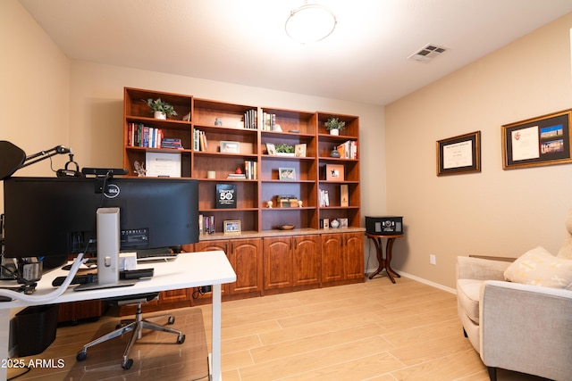 office featuring light wood-type flooring, visible vents, and baseboards