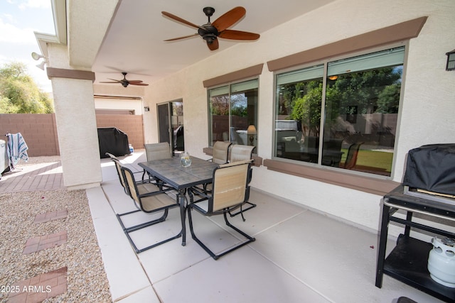 view of patio / terrace featuring fence, outdoor dining area, and a ceiling fan