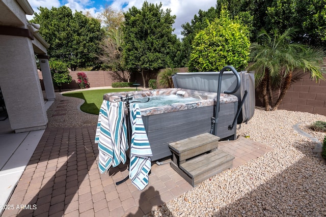 exterior space with a hot tub and a fenced backyard