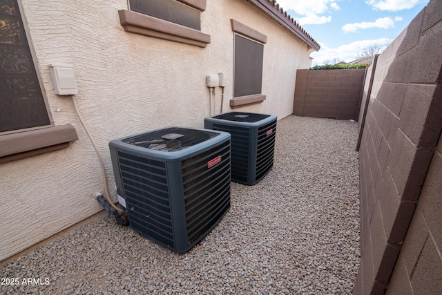 details featuring stucco siding, a fenced backyard, and central AC unit