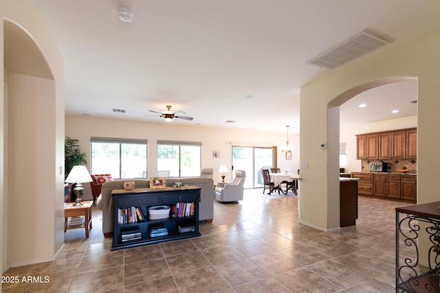 living area with recessed lighting, visible vents, arched walkways, and tile patterned floors