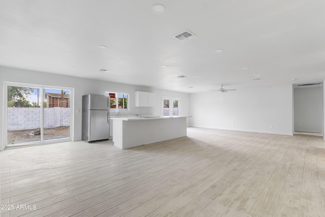 13804 N 52nd Dr, Glendale, AZ 85306 - unfurnished living room featuring plenty of natural light, light wood finished floors, and a ceiling fan
