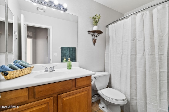 bathroom with tile patterned flooring, vanity, and toilet