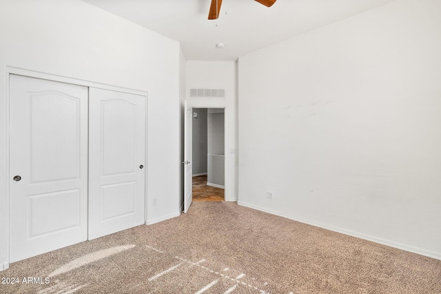 unfurnished bedroom with ceiling fan, carpet floors, and a closet