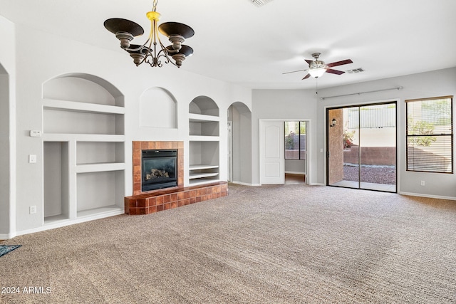 unfurnished living room with carpet flooring, ceiling fan with notable chandelier, built in features, and a fireplace