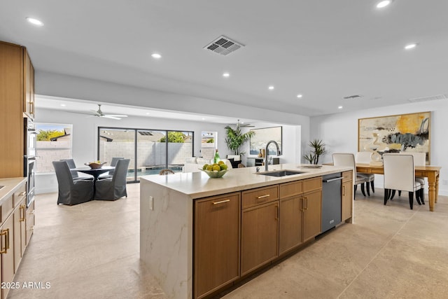 kitchen with a sink, dishwasher, light countertops, an island with sink, and recessed lighting