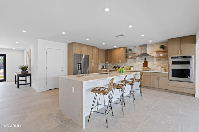 kitchen with open shelves, wall chimney range hood, tasteful backsplash, a sink, and stainless steel appliances