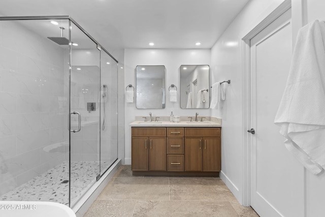 full bathroom with double vanity, a sink, a stall shower, and recessed lighting