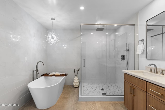 bathroom featuring vanity, a freestanding tub, and a stall shower