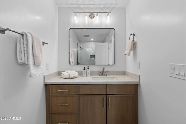 full bath featuring vanity, a shower, and visible vents