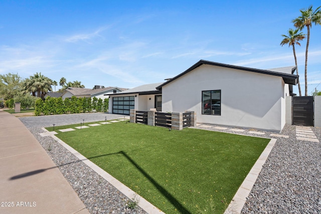 view of front facade with fence, an attached garage, a front lawn, stucco siding, and concrete driveway