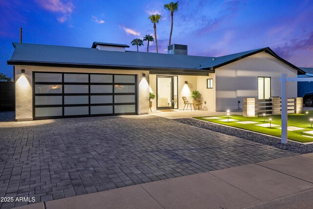 8430 E Fairmount Ave, Scottsdale, AZ 85251 - view of front of home featuring decorative driveway, an attached garage, stucco siding, and a chimney