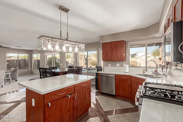 kitchen featuring a center island, sink, appliances with stainless steel finishes, decorative light fixtures, and light tile patterned flooring