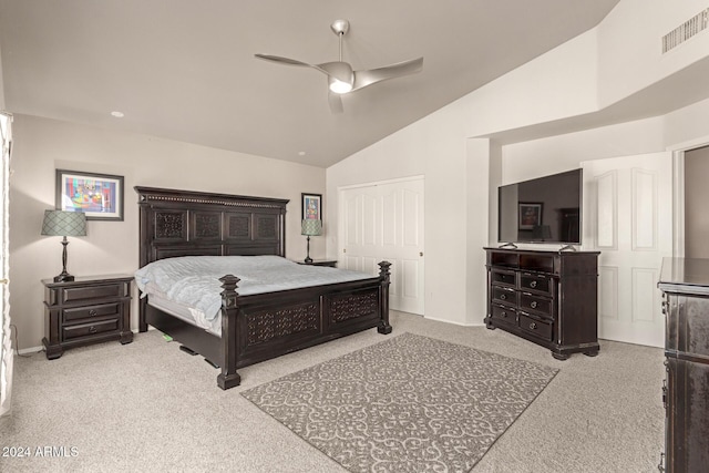 bedroom featuring ceiling fan, a closet, light colored carpet, and vaulted ceiling